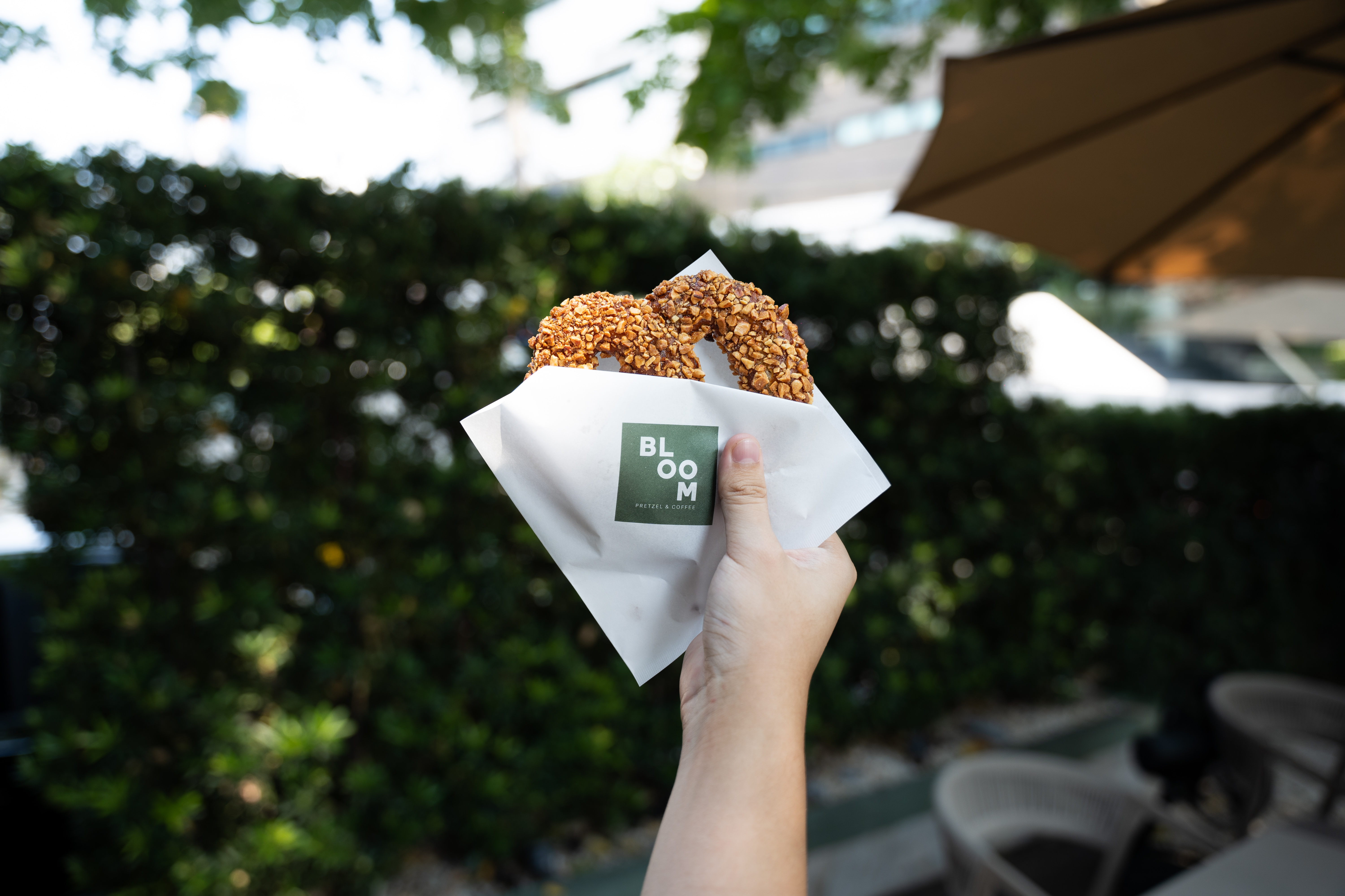 Bloom Neighborhood Dining Rama 9 exterior — white two-storey house surrounded by mature trees with outdoor garden seating Bangkok