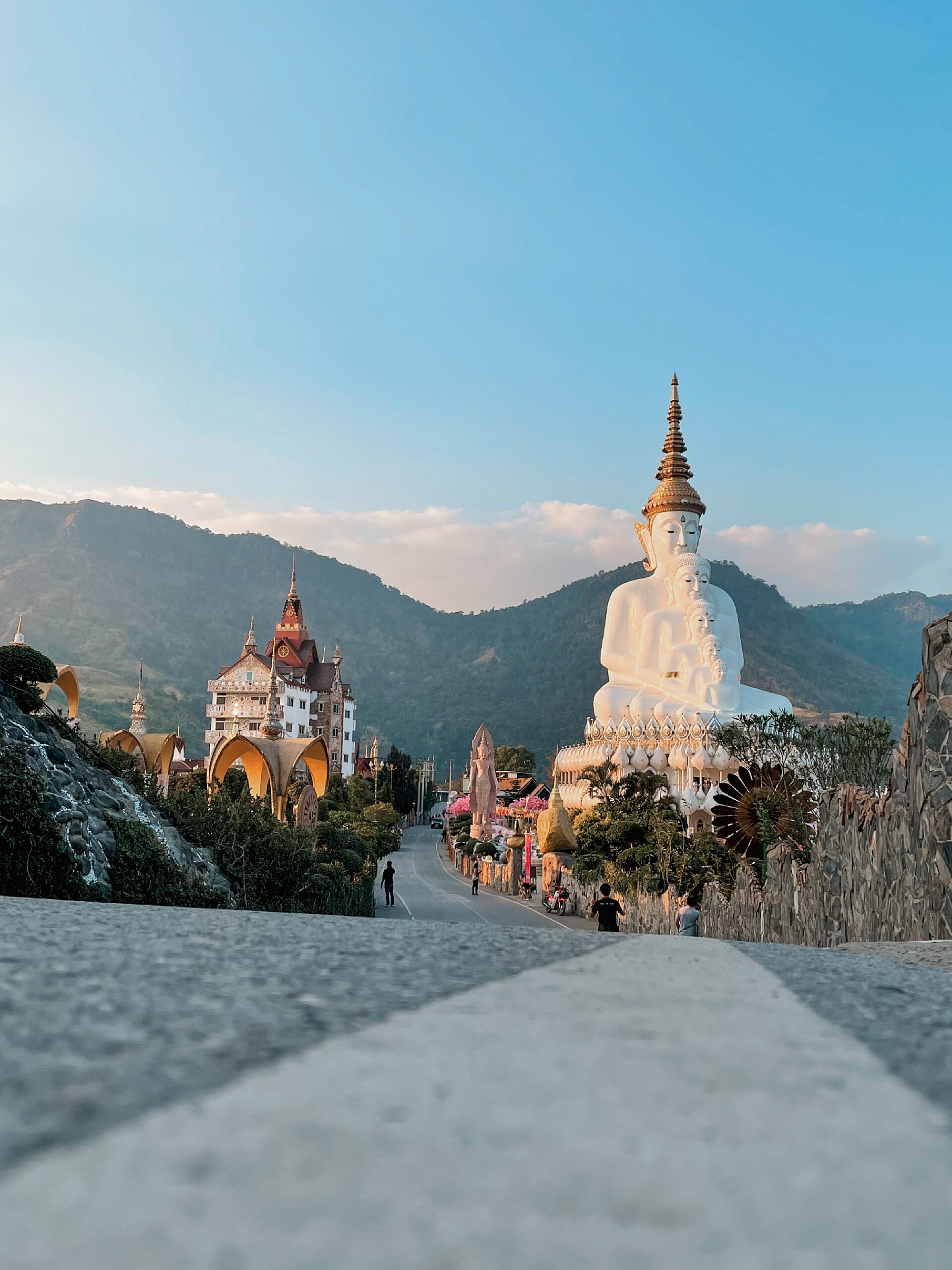 Five white Buddha images and mountains at Wat Pha Son Kaew