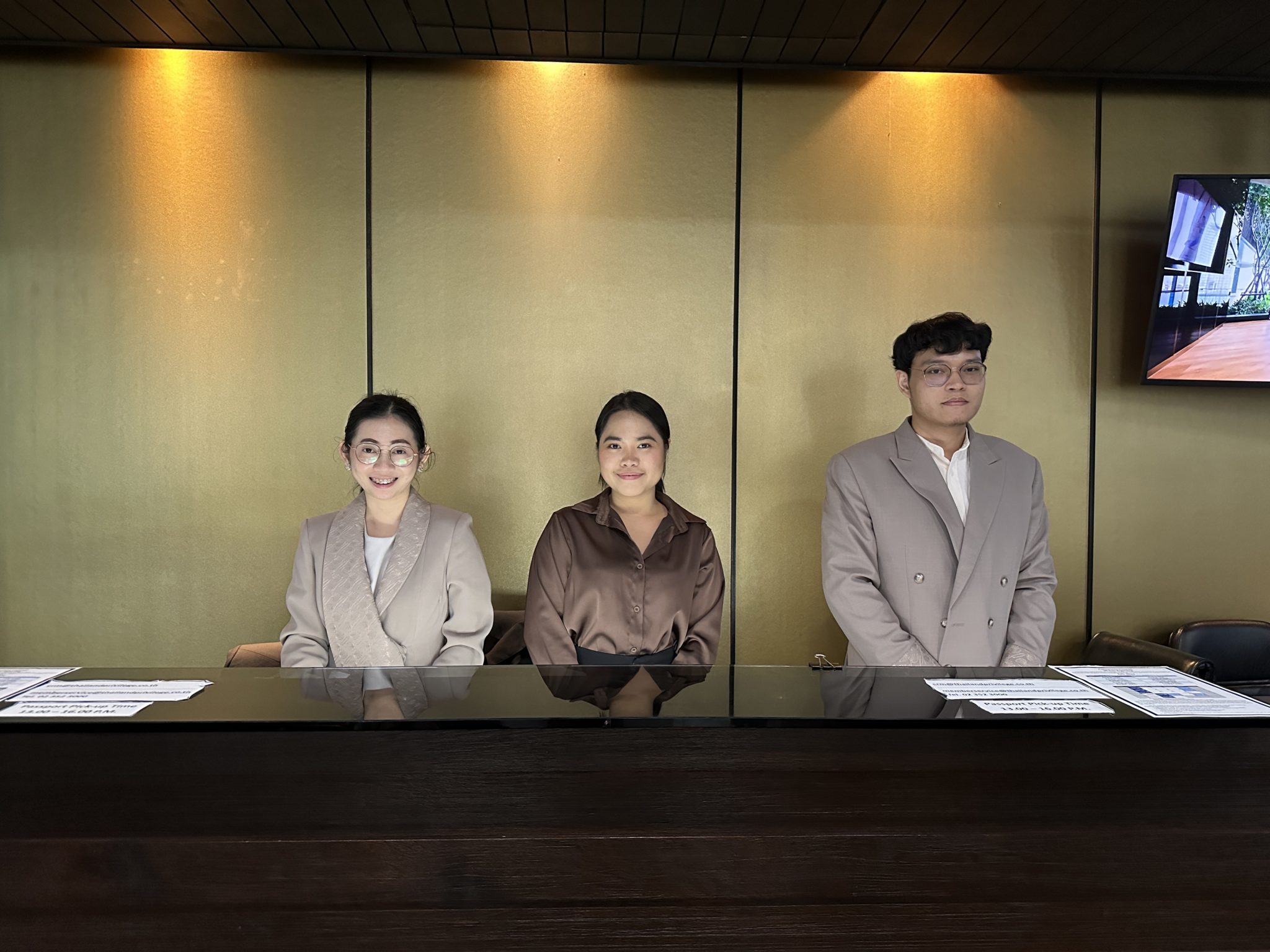 Thailand Privilege Card service team smiling at the reception desk, ready to assist long-stay visa members in Bangkok