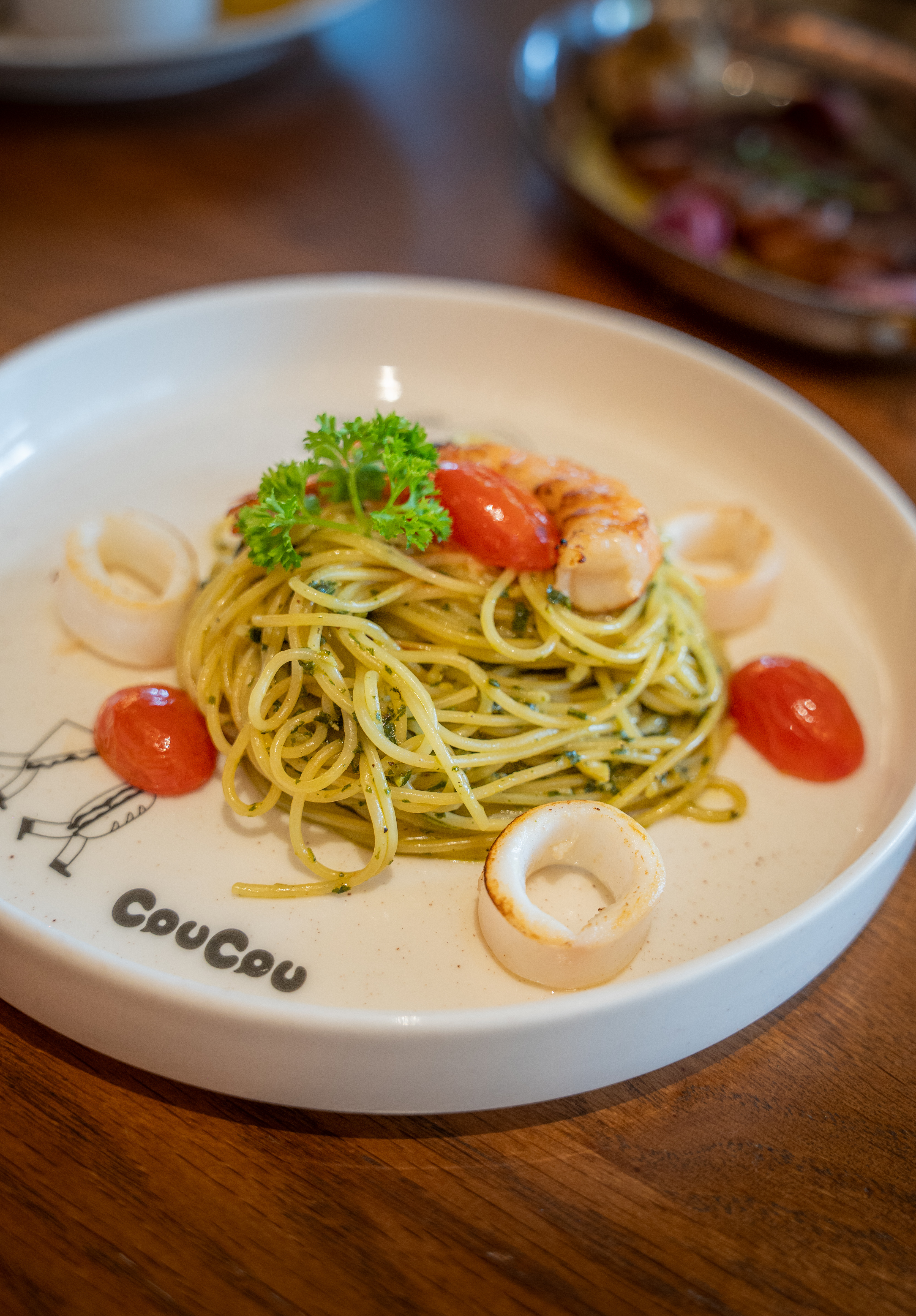 A plate of homemade pasta with seafood, cherry tomatoes and fresh herbs, highlighting the Italian-inspired dishes at CouCou All Day Bangkok.
