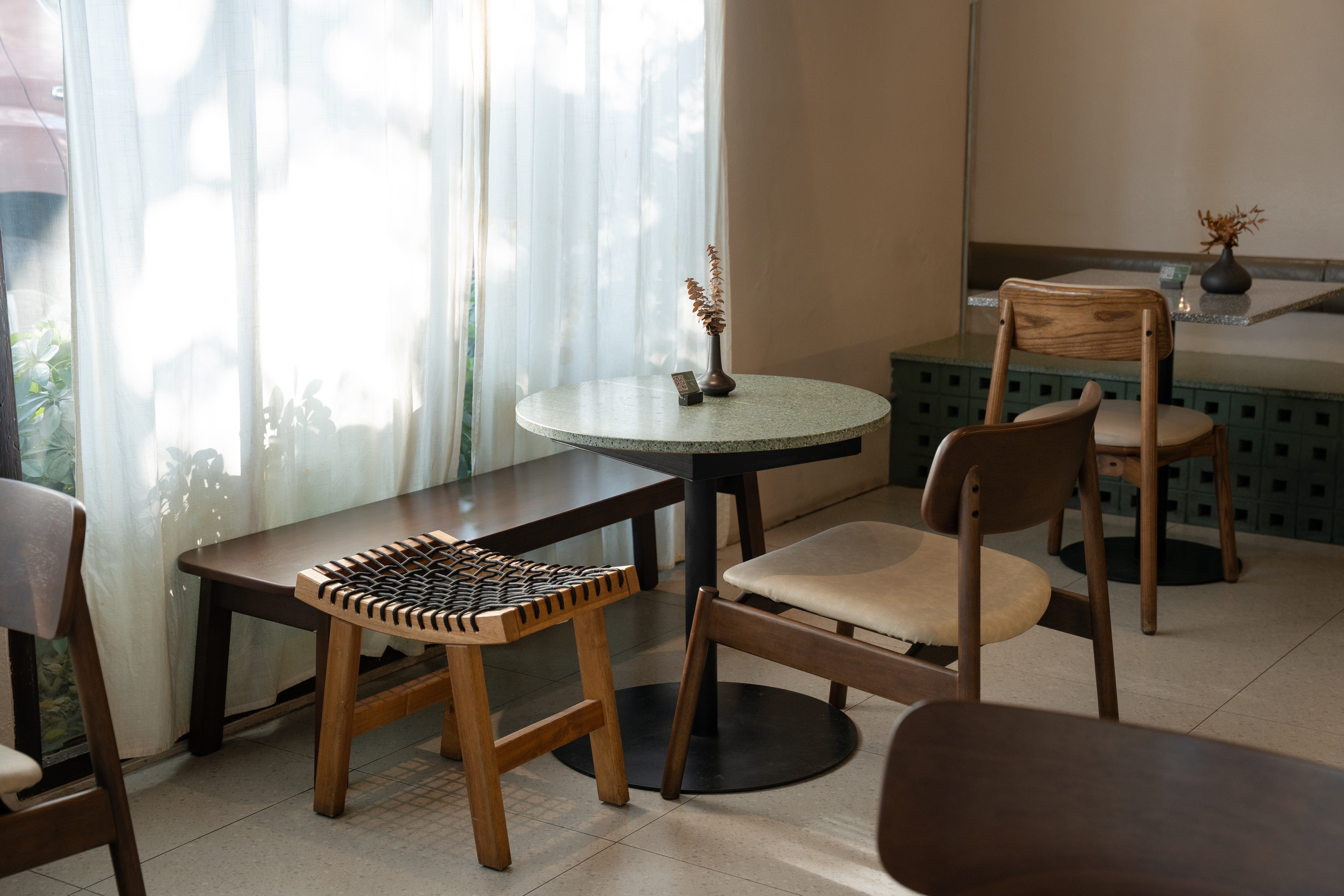Bloom Dining Bangkok Mango Sorbet dessert served on ceramic plate atop green terrazzo table, seasonal dessert menu Bangkok