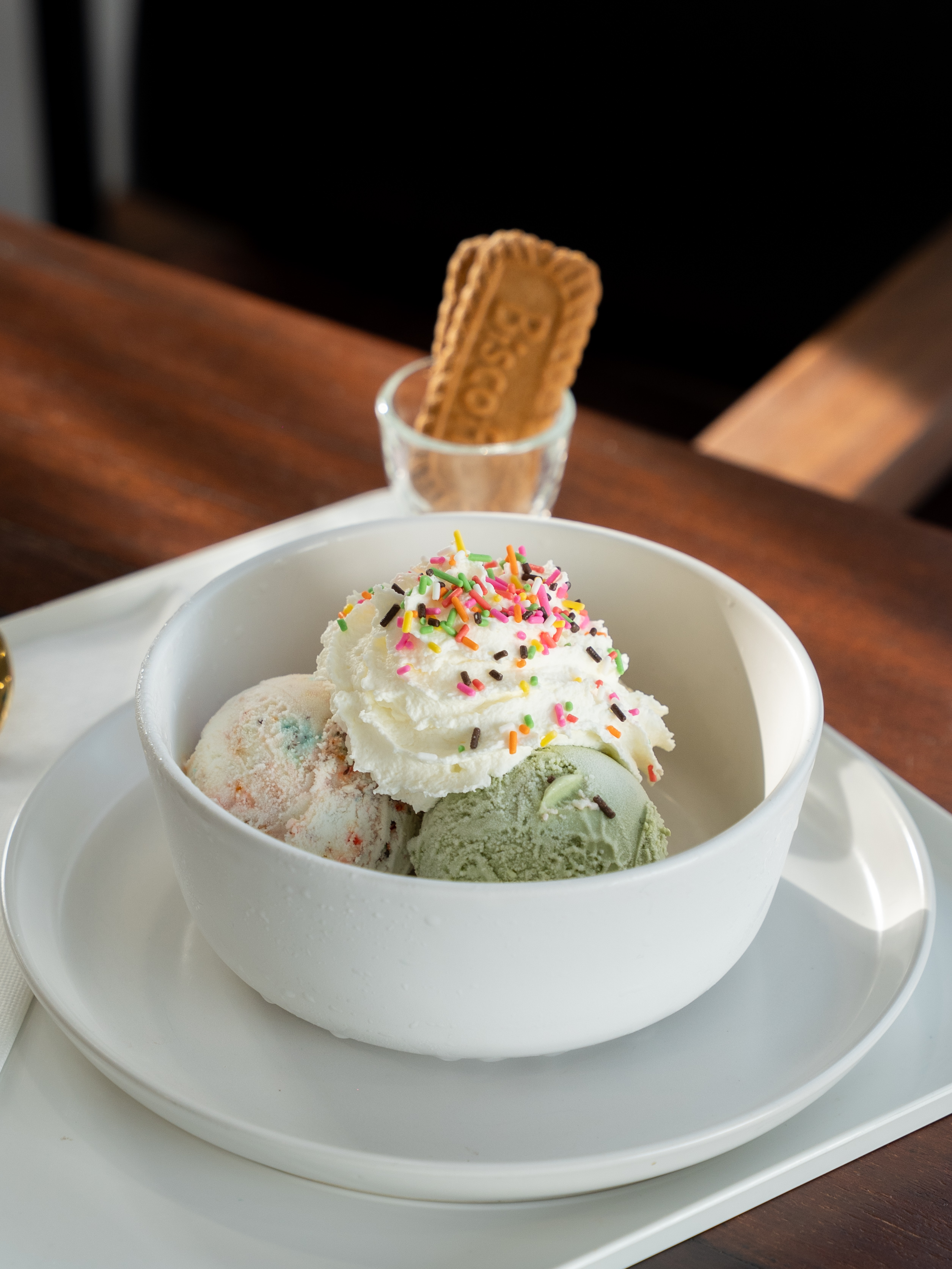 Delicious ice cream scoops topped with whipped cream and colorful sprinkles at Duckie Doze Bangkok.