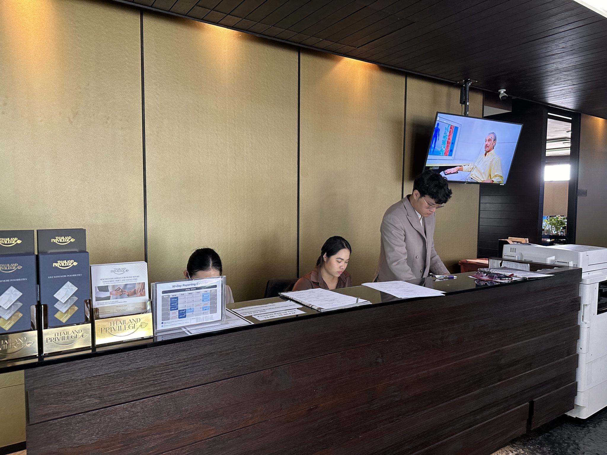 Thailand Privilege Card staff assisting members at the reception desk in their Bangkok office