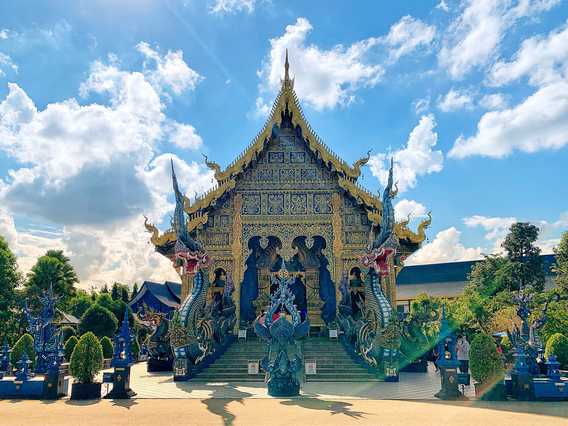 Blue and gold vihara of the Blue Temple Chiang Rai under a clear sky