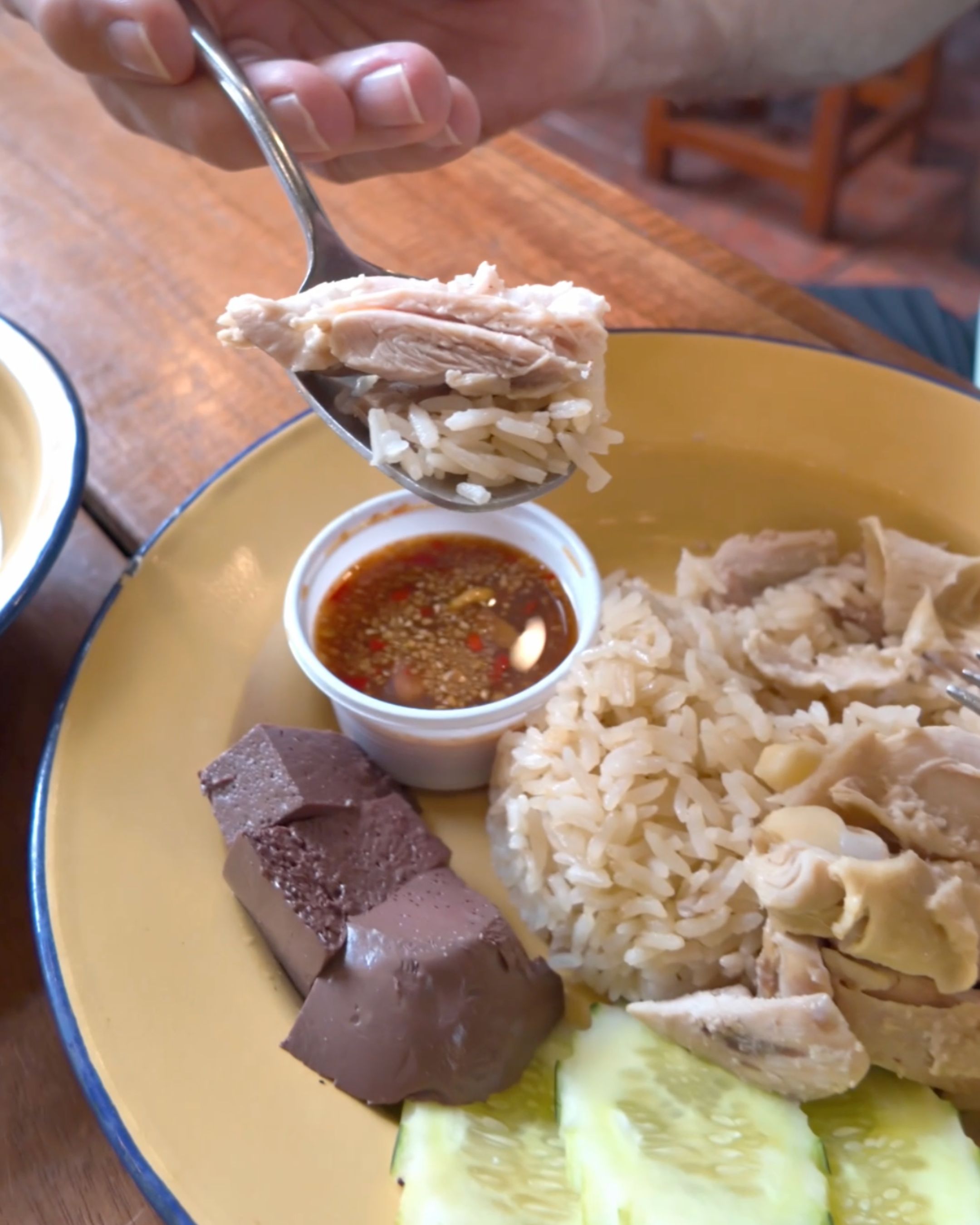 A traditional Thai meal featuring rice, sliced chicken, dipping sauce and other local ingredients, showcasing the flavors of Thai cuisine at Imem Thai Dishes Bangkok.