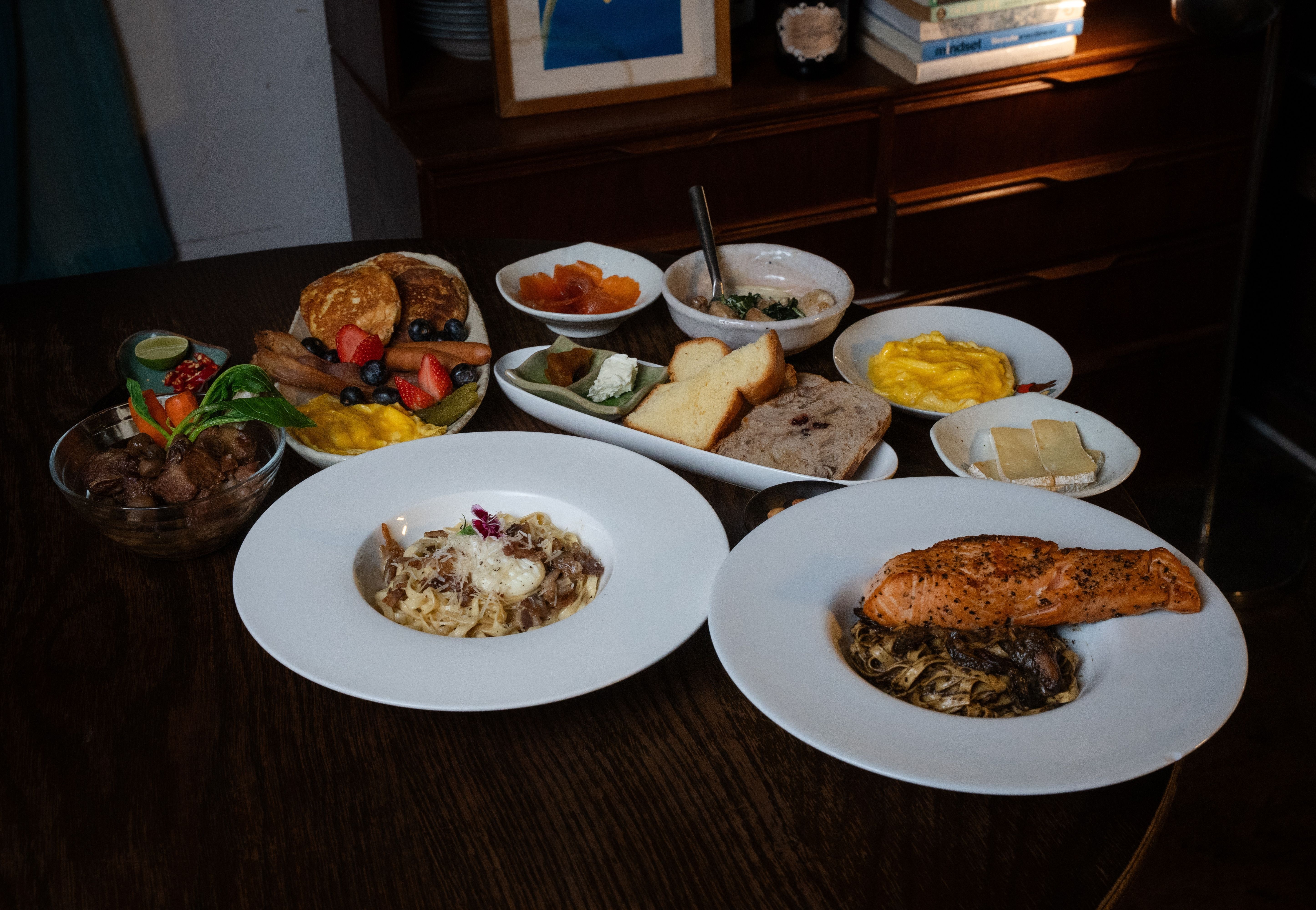 Full brunch spread with pasta, salmon, scrambled eggs, and bread at Camelot Café Bangkok Charoen Krung
